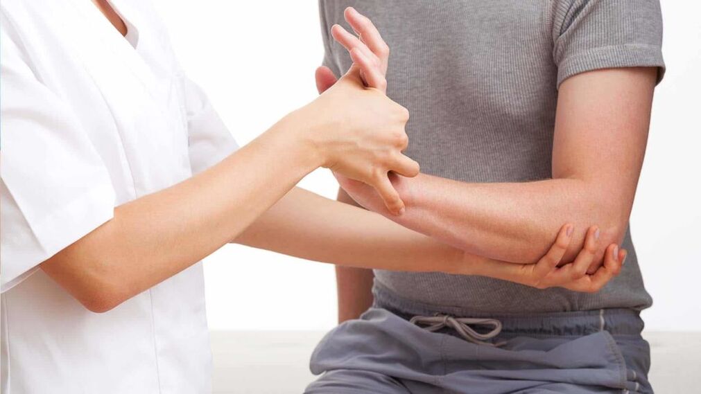 medico che esamina una mano con l'artrite